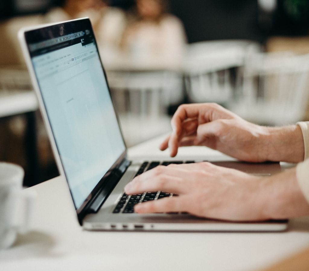 Person typing on a computer to write an email