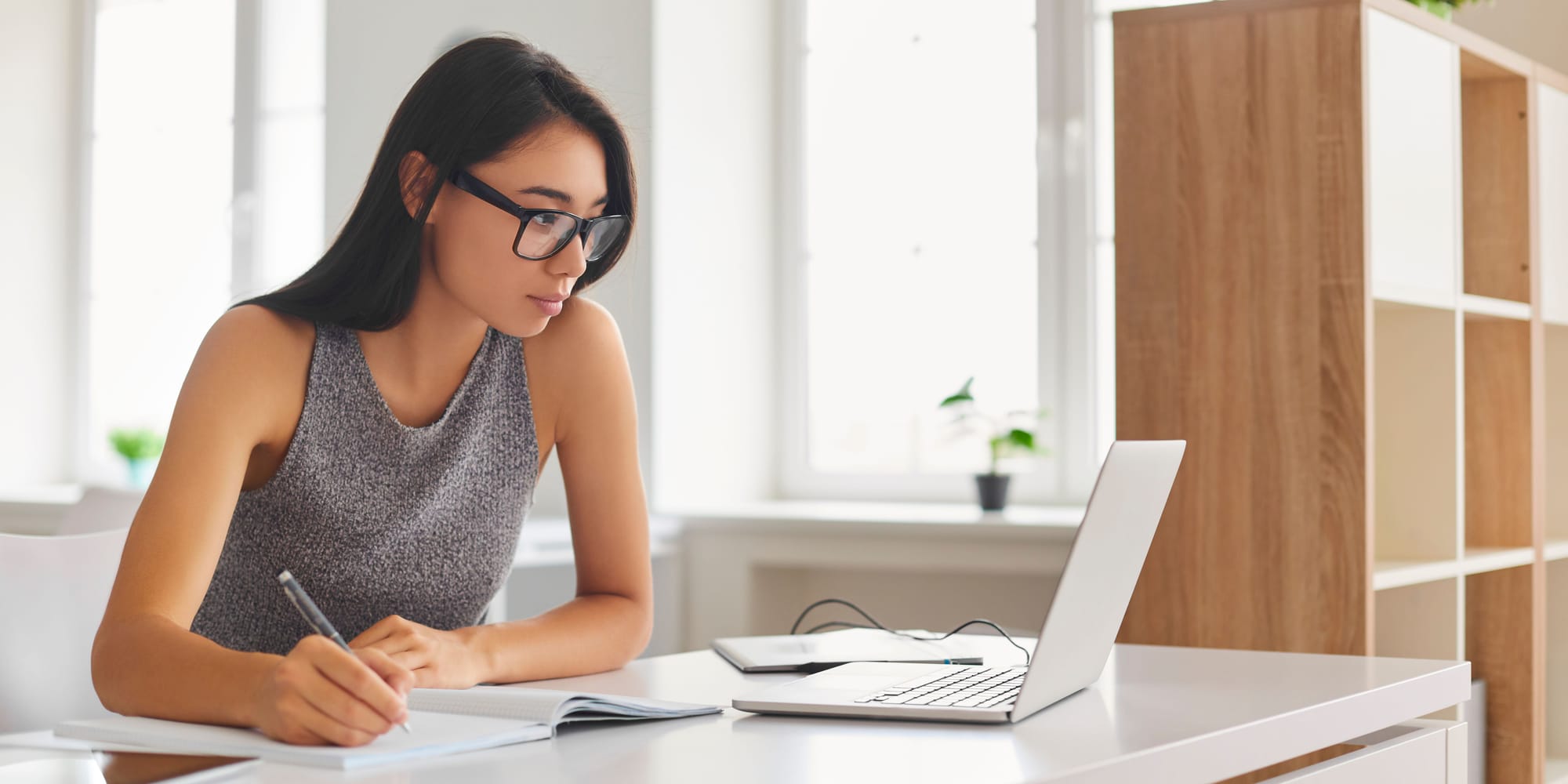 a woman is taking a note from a laptop