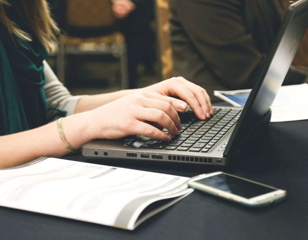 a woman typing on a laptop