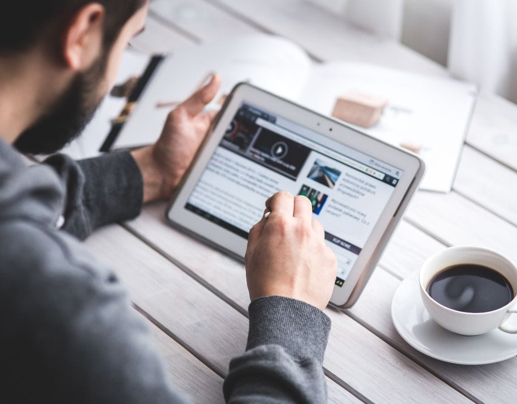 a man reading news from an iPad