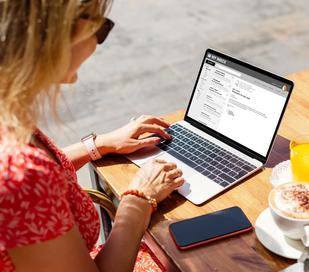 a woman writing follow up email after meeting with her laptop