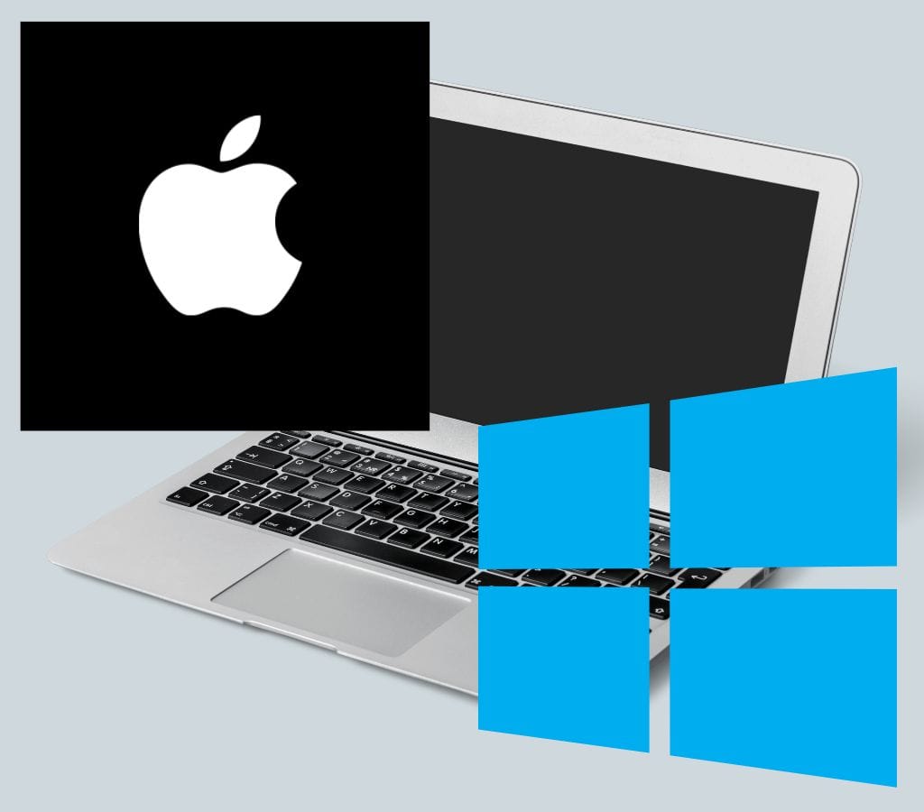 a laptop siting on a desk with apple logo and windows logo